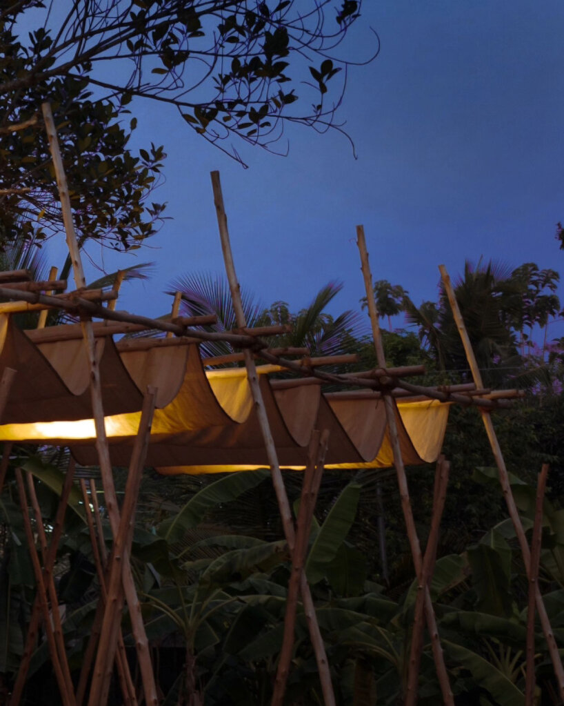 swooping fabric weaves through studio terratects' wooden trestle pavilion in india