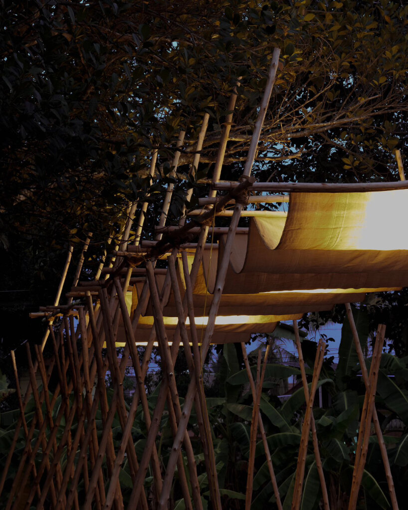 swooping fabric weaves through studio terratects' wooden trestle pavilion in india