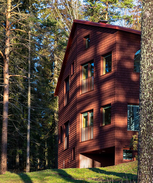 ornamental wooden castle in finland restored with red-shingled guest house