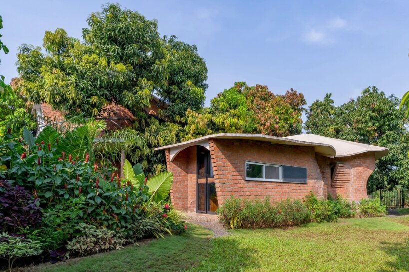 curved brick walls wrap biophilic farmhouse by blurring boundaries in mumbai mangro grove