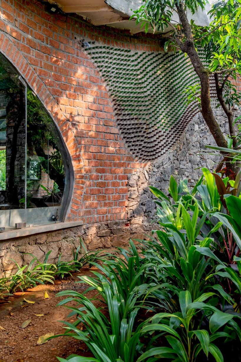 curved brick walls wrap biophilic farmhouse by blurring boundaries in mumbai mangro grove