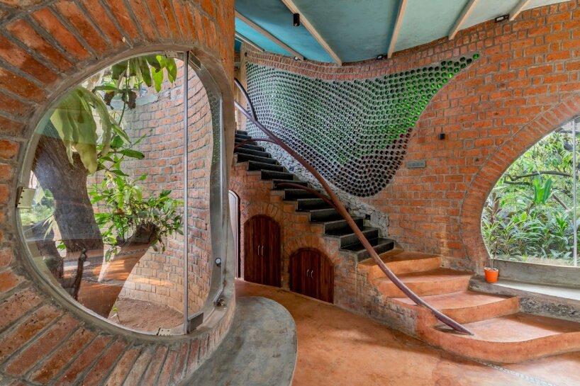 curved brick walls wrap biophilic farmhouse by blurring boundaries in mumbai mangro grove