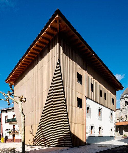 vertical wooden slats clad irura town hall's polyhedral facade in spain