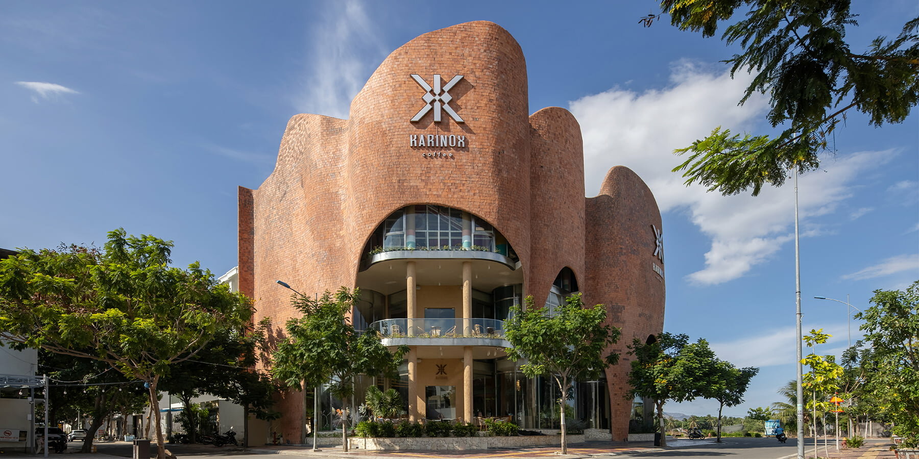 fluid brick-clad facade undulates around karinox coffee shop in vietnam