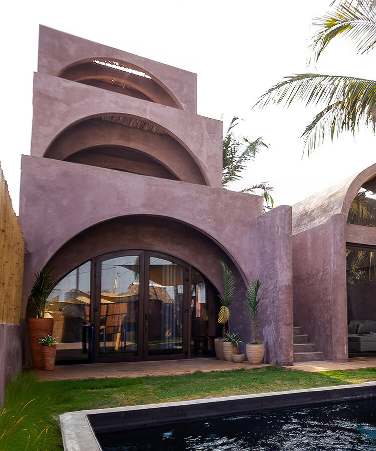 palm trees become part of casa onda's arched facade in guatemala surf town