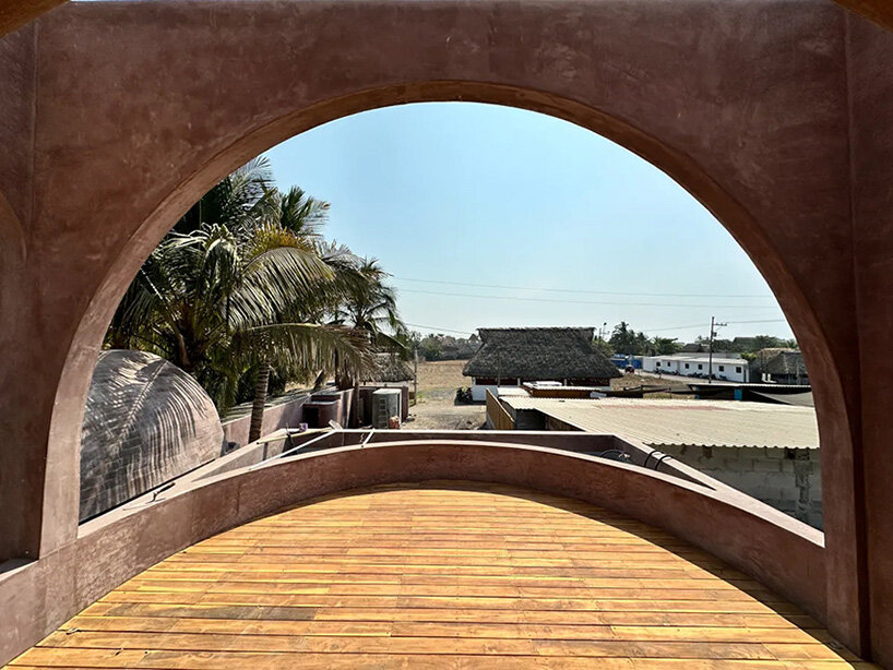 palm trees become part of casa onda's arched facade in guatemala surf town