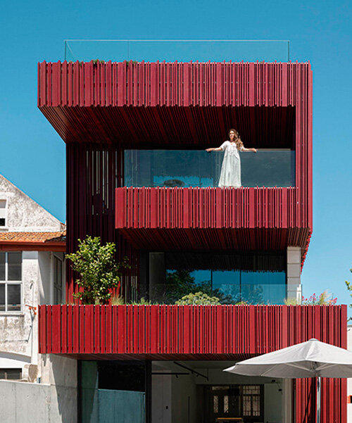 red timber-clad skin embraces park house's art nouveau facade in aveiro