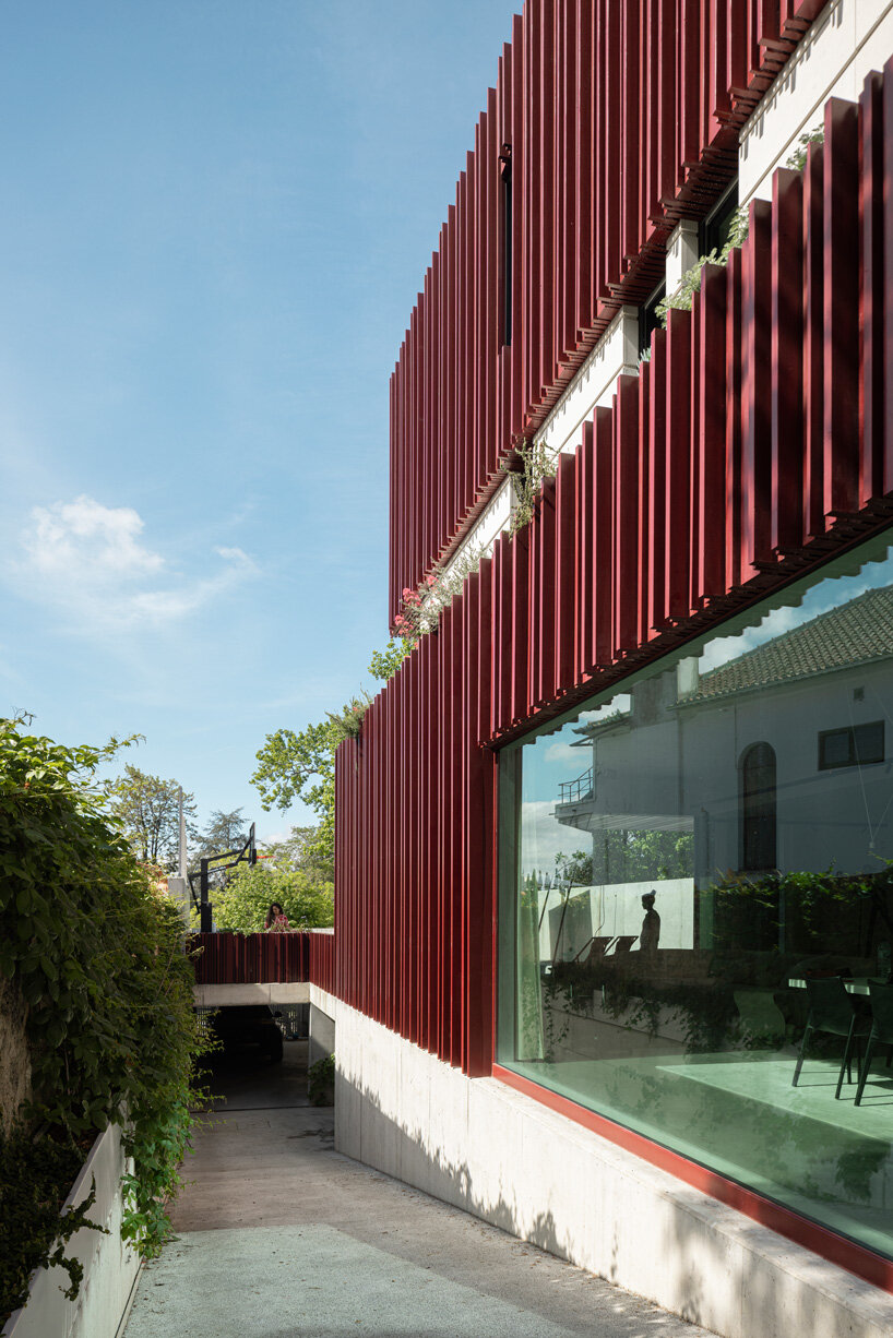 red timber-clad skin embraces park house's art nouveau facade in aveiro