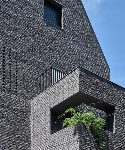 a round architects sculpts seoul office building with dark, rusticated stone bricks