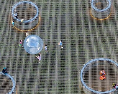 zxd architects stretches large woven net across pond in rural china, inviting rest and play