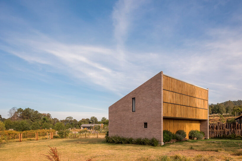 Una pequeña casa geométrica de ladrillo de Estudio Atemporal Crafts en el paisaje rural de México