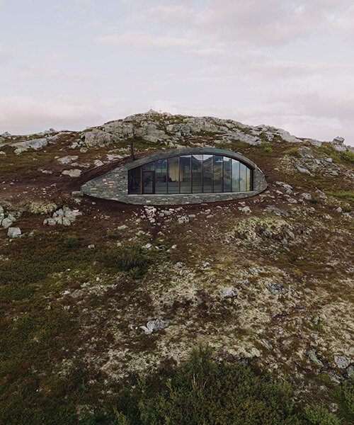 gazing over scenic norway, aksent arkitekter's day-trip cabin is embedded into a mountain