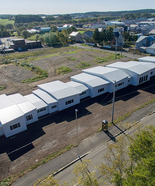 a series of small gabled homes forms atelier meme's specialized school in japan