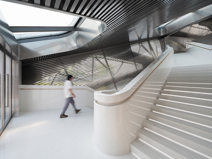 faceted glass curtain walls flood DJI's shenzhen origami-like flagship store with sunlight