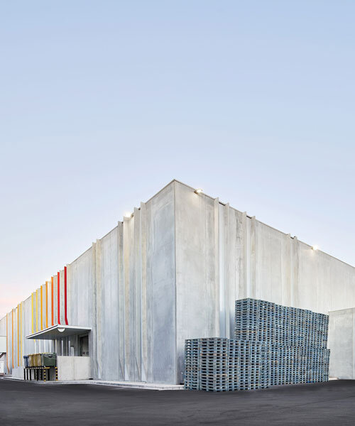 red and orange grooves brighten up factory's concrete facade by ARQUID in barcelona