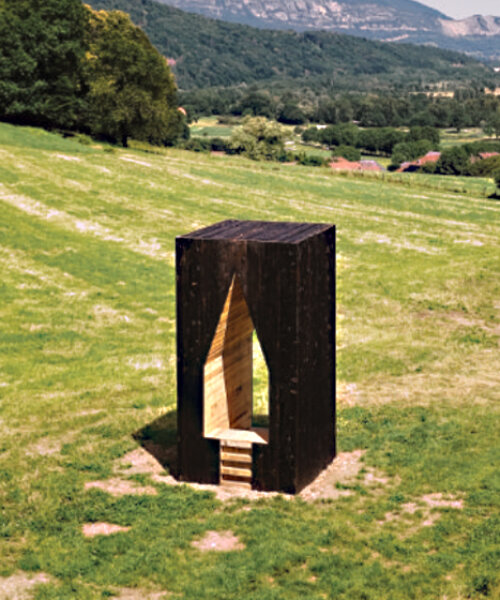 triangular void punctures lake odyssey hut's wooden monolith in fields of france