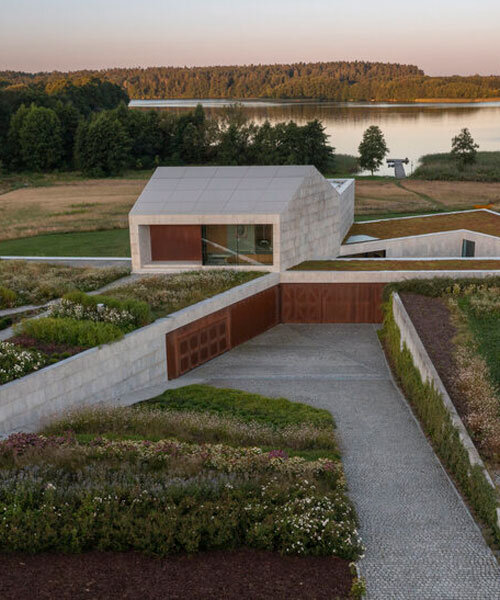 modern stone-clad farmhouse by mobius architekci folds along polish landscape's nooks