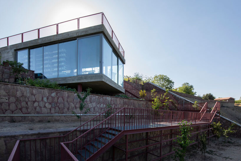 La oficina ayeneh, con sede en Teherán, diseña una estantería suspendida para flotar dentro del volumen de vidrio de la villa