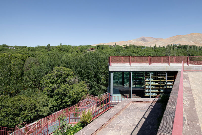 La oficina ayeneh, con sede en Teherán, diseña una estantería suspendida para flotar dentro del volumen de vidrio de la villa