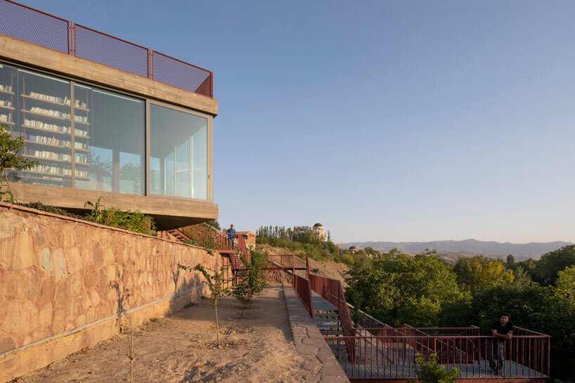 La oficina ayeneh, con sede en Teherán, diseña una estantería suspendida para flotar dentro del volumen de vidrio de la villa