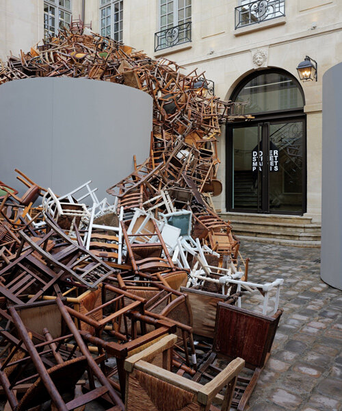 tadashi kawamata's tumbling avalanche of wooden chairs sweeps through paris courtyard