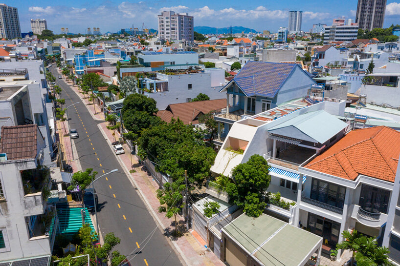 Los recortes en el techo inclinado de hormigón iluminan una casa en Vietnam por DMA Architects