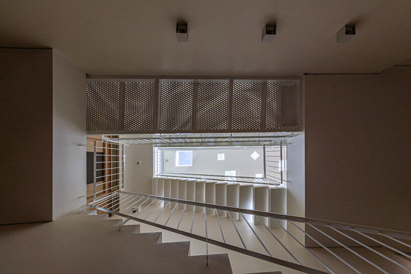 Los recortes en el techo inclinado de hormigón iluminan una casa en Vietnam por DMA Architects