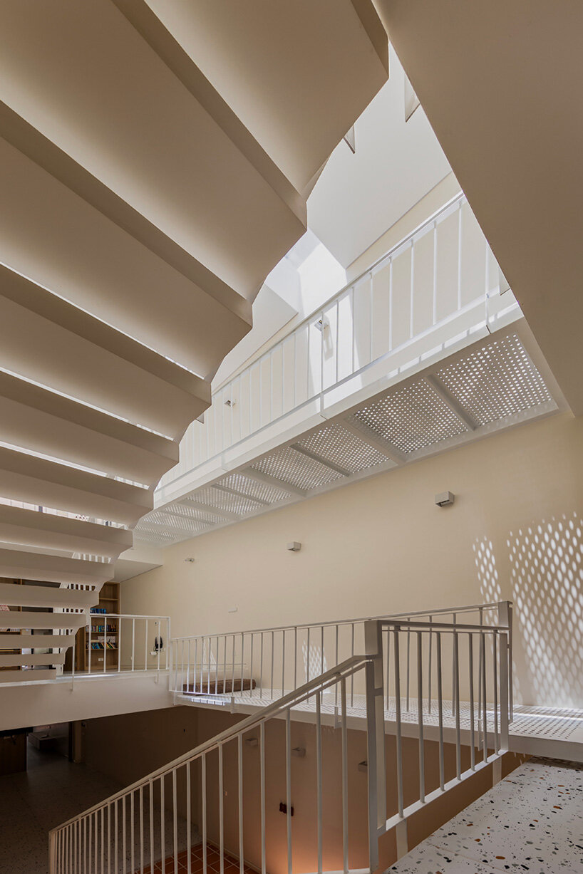 cutouts in slanted concrete roof illuminate vietnamese residence by DMA architects