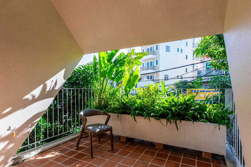 Los recortes en el techo inclinado de hormigón iluminan una casa en Vietnam por DMA Architects