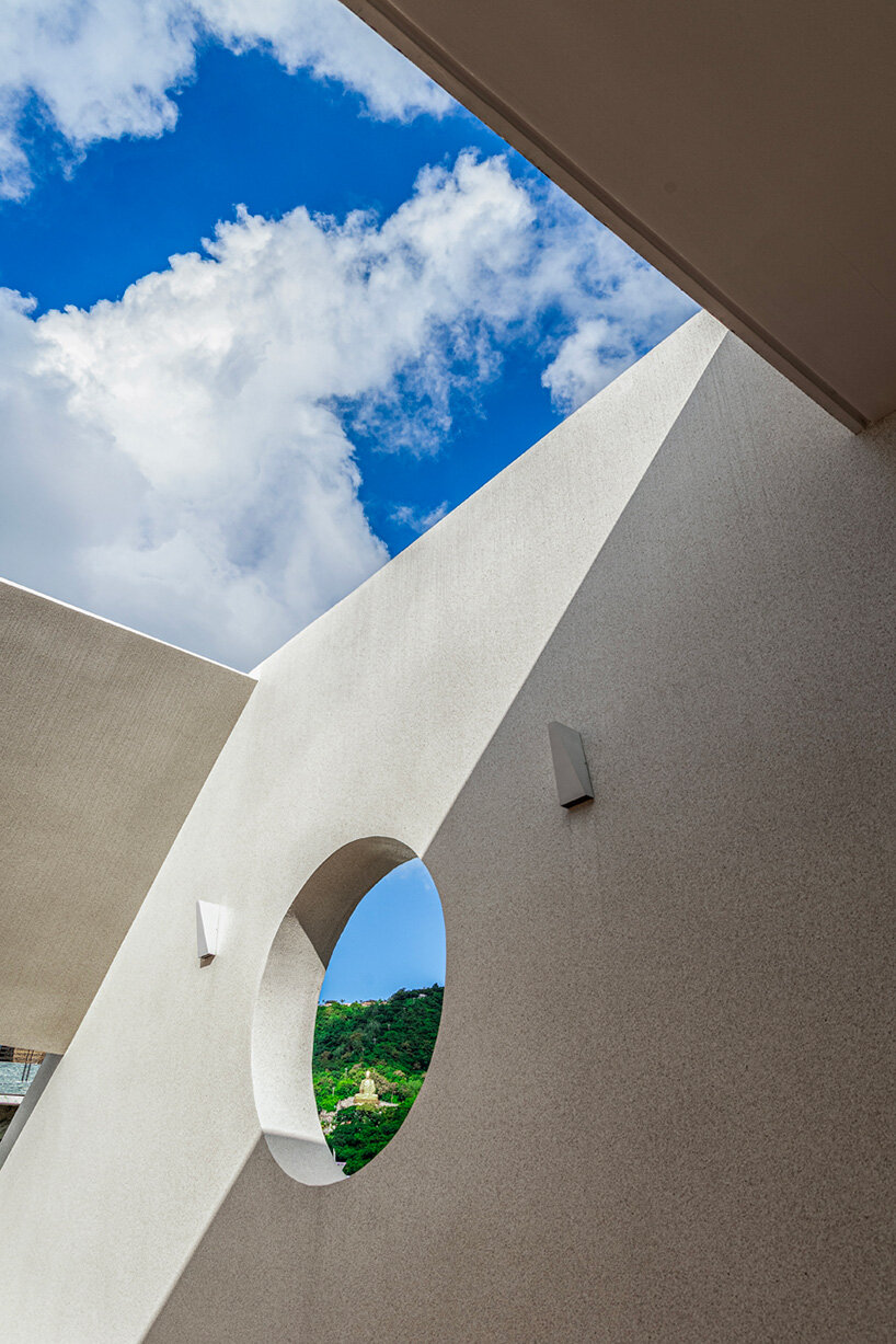 Los recortes en el techo inclinado de hormigón iluminan una casa en Vietnam por DMA Architects