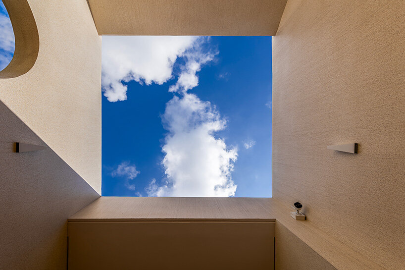 cutouts in slanted concrete roof illuminate vietnamese residence by DMA architects
