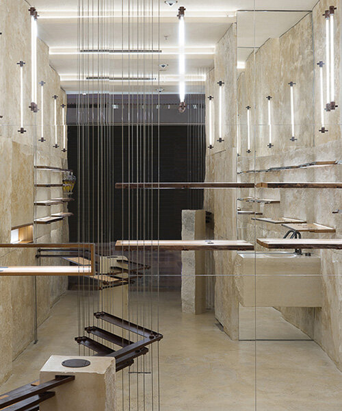 quarries inspire adjustable shelving system in dongqi design's stone-clad shanghai store