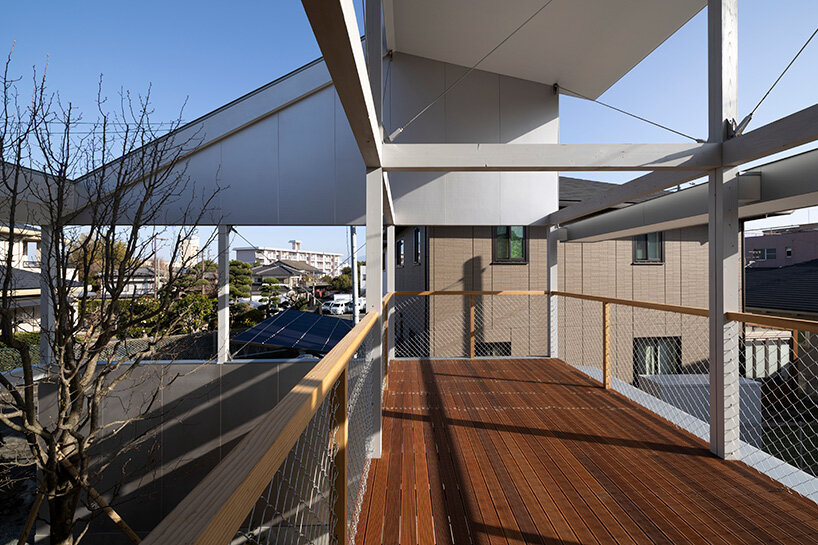 silver panels mirror japanese cityscape on goya schröder’s wooden-framed residence