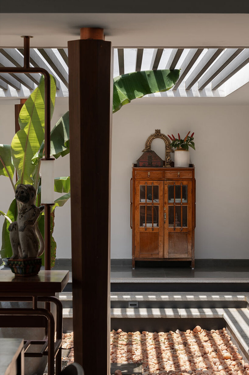 pitched roof volume cantilevers from thomas parambil's house amid kerala paddy fields