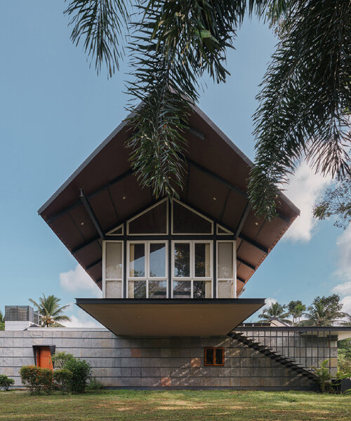 pitched roof volume cantilevers from thomas parambil's house amid kerala paddy fields