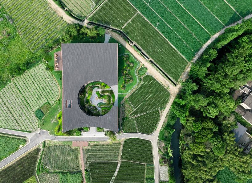homme architects' round opening above tourist center frames bamboo garden in china fields
