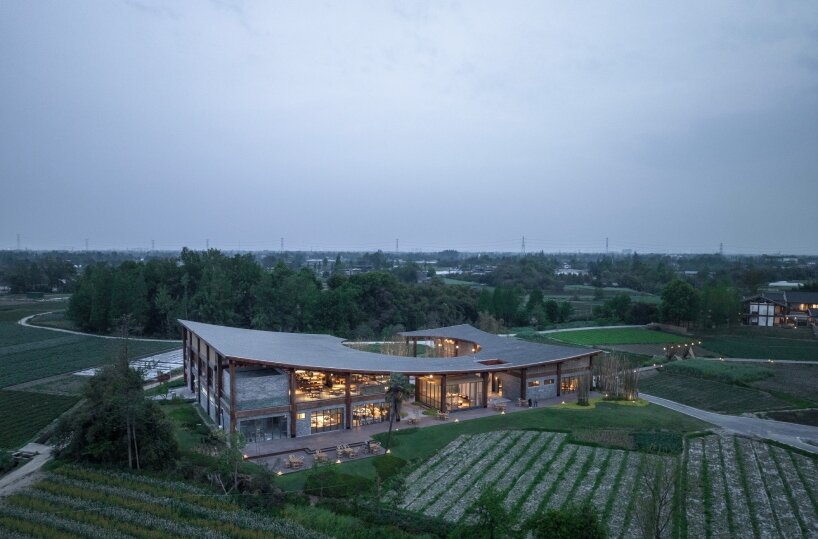 homme architects' round opening above tourist center frames bamboo garden in china fields