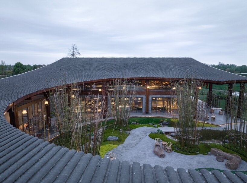 homme architects' round opening above tourist center frames bamboo garden in china fields
