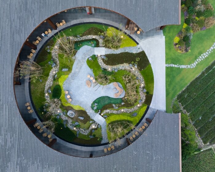 homme architects' round opening above tourist center frames bamboo garden in china fields