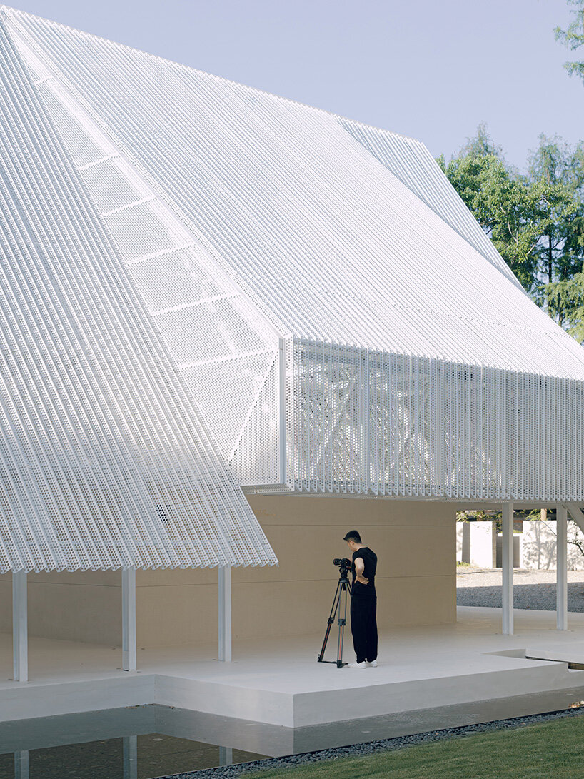 wing-like roof covers open gathering area by SHISUO in shanghai's memorial park