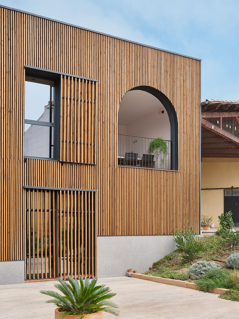 wooden sliding shutters frame arched openings in spanish renovation by sergi pons studio