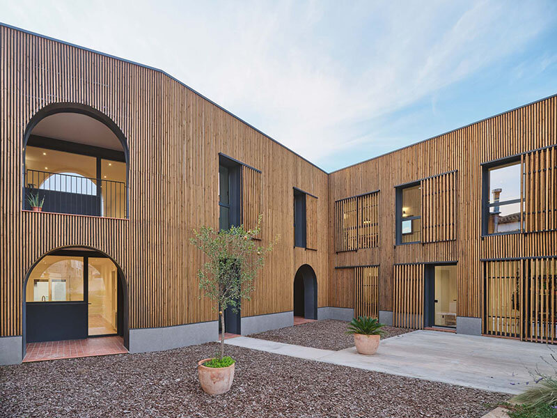 wooden sliding shutters frame arched openings in spanish renovation by sergi pons studio