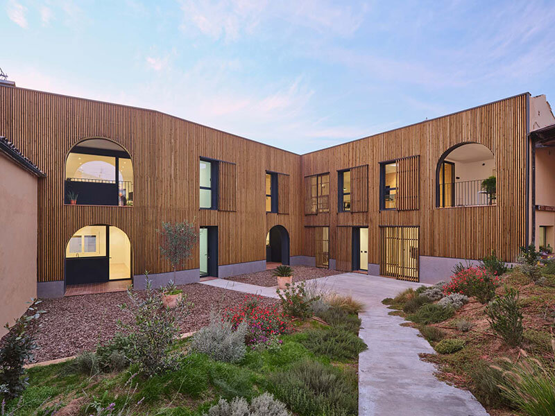 wooden sliding shutters frame arched openings in spanish renovation by sergi pons studio
