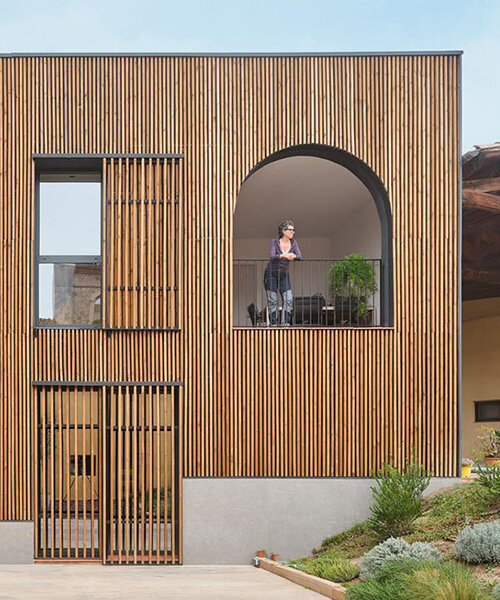 wooden sliding shutters frame arched openings in spanish renovation by sergi pons studio