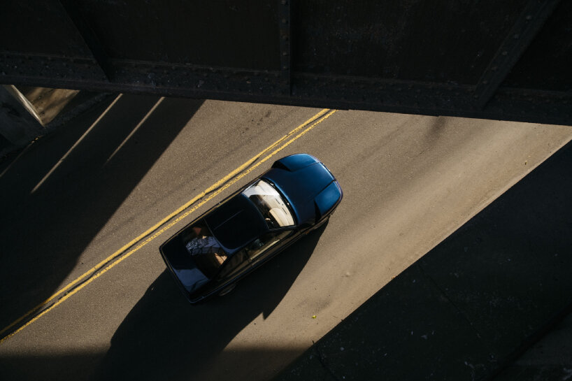 the photographer stands above streets and bridges to capture the aerial images