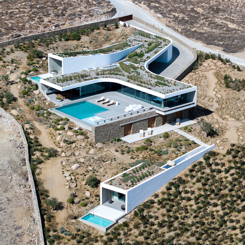 curved dry stone wall outlines villa by A31 and tom dixon emerging from mykonian hillside