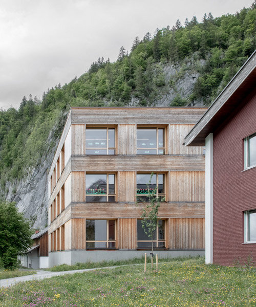 bernardo bader architekten tucks timber school beneath mountain peaks of au, austria