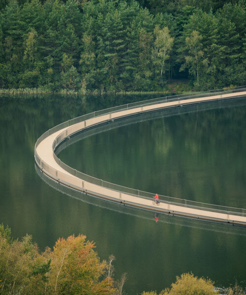 floating cycling bridge curves through pond in belgium adapting to water levels