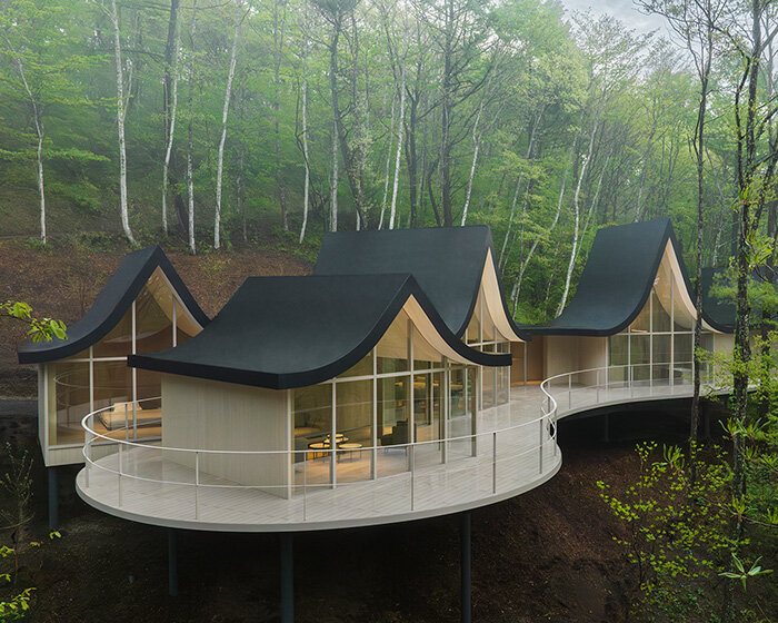 nendo weaves six cottages together with 'hand-holding' roofs in japanese forest house