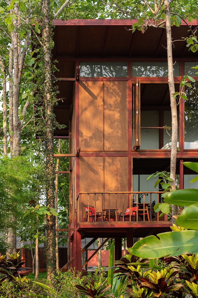 Aksen kayu dan merah yang direklamasi menentukan renovasi Lodge Garden Pembuat Sher di Thailand